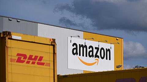 Ein Logistikzentrum von Amazon, auf dessen Gelände DHL-Container stehen. DHL ist das größte Paketunternehmen in Deutschland, gefolgt von Amazon - der Online-Handelsriese trägt einen großen Teil bei ihm bestellten Waren selbst aus. (Archivbild)