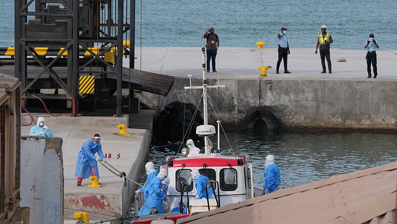 Gesundheitspersonal in Schutzkleidung evakuiert Patienten vom Kreuzfahrtschiff "Hondius" in einem Hafen.