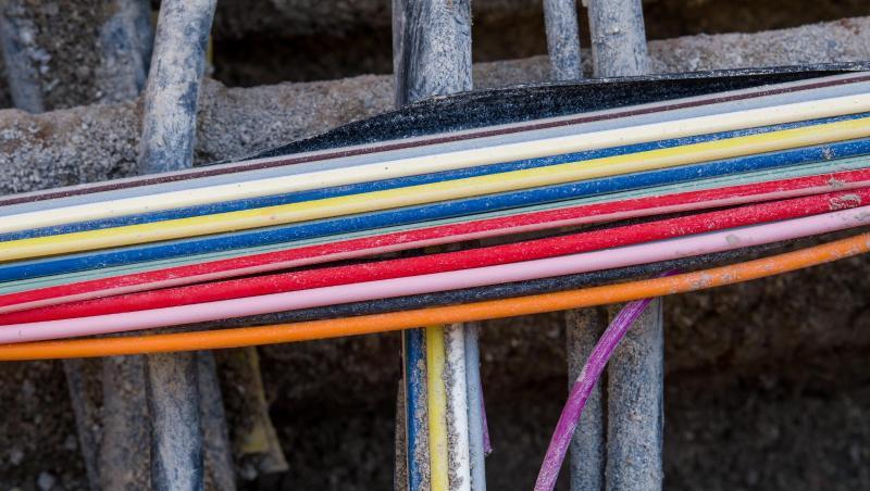 Bunte Glasfaserkabel für die Telekommunikation liegen in einer Baugrube zwischen anderen Leitungen. Foto: Peter Kneffel/Archivbild Bunte Glasfaserkabel für die Telekommunikation liegen in einer Baugrube zwischen anderen Leitungen. Foto: Peter Kneffel/Archivbild