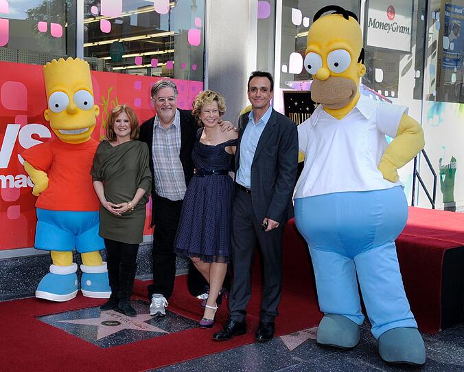 Bart Simpson (l.) und Homer Simpson (r.), mit Nancy Cartwright (2.v.l.), Yeardley Smith (3.v.r.) und Hank Azaria (2.v.r.) mit Matt Groening.