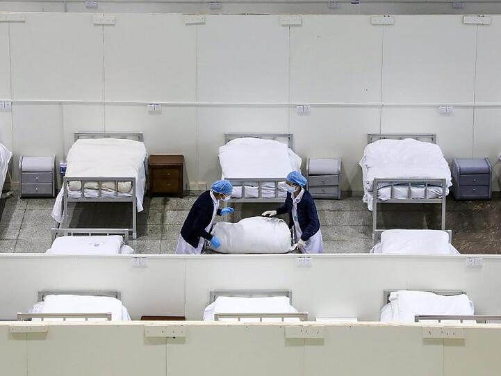 Medizinisches Personal bereitet Betten in einem provisorischen Krankenhaus vor.