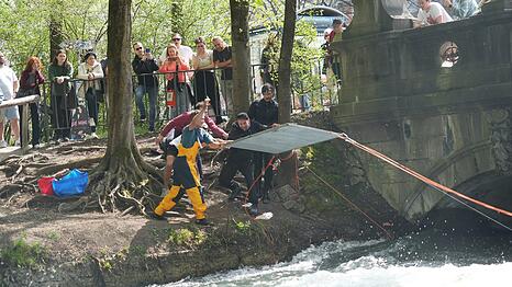 Drei, zwo, eins: Hier werfen der Str&ouml;mungsexperte Robert-Meier Staude und sein Team ein an Seilen aufgeh&auml;ngtes Gitter f&uuml;r den Testversuch in den Eisbach.