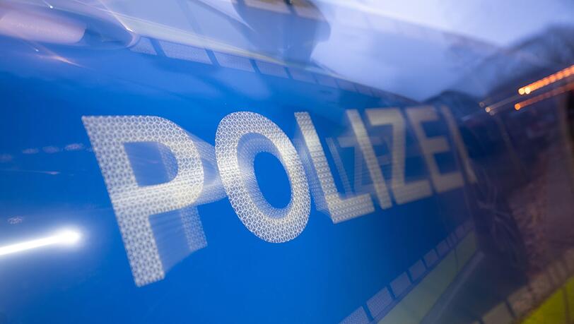 Das Wort Polizei ist iauf der Karosserie eines Polizeifahrzeugs zu sehen.