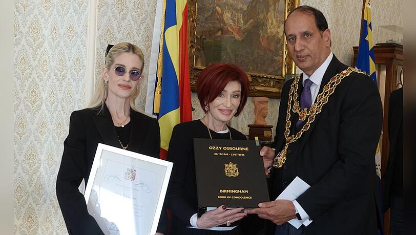 Kelly (l.) und Sharon Osbourne bekamen vom Oberbürgermeister von Birmingham, Zafar Iqbal, die posthume Ehrung für Ozzy Osbourne überreicht. Kelly (l.) und Sharon Osbourne bekamen vom Oberbürgermeister von Birmingham, Zafar Iqbal, die posthume Ehrung für Ozzy Osbourne überreicht.