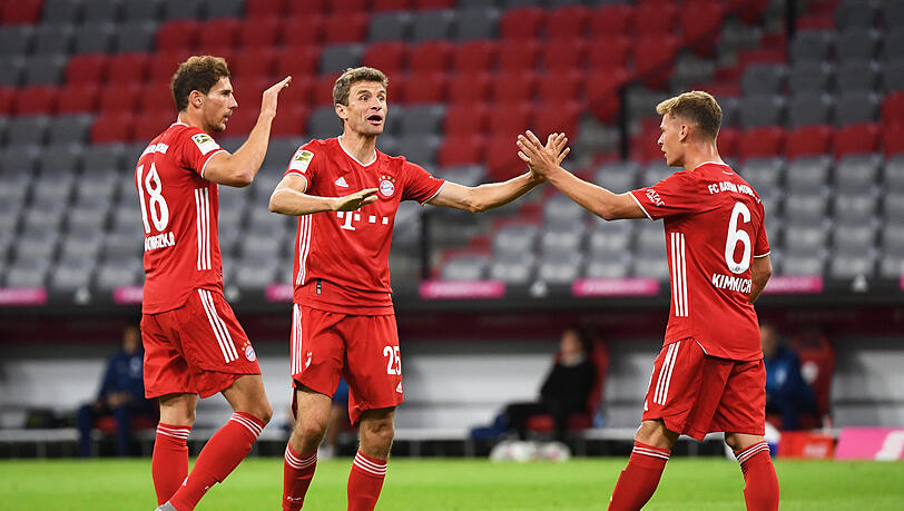 Leon Goretzka (links) lässt sich nach seinem Treffer zum zwischenzeitlichen 2:0 gegen den FC Schalke 04 (Endstand 8:0) von seinen Bayern-Teamkollegen Thomas Müller und Joshua Kimmich feiern.