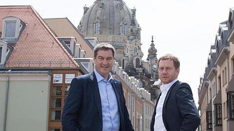 Ministerpräsident Michael Kretschmer (r) und Ministerpräsident Markus Söder stehen vor der Frauenkirche. Foto: Sebastian Kahnert