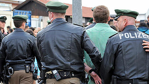 Ein Schläger auf der Wiesn wird von der Polizei abgeführt.