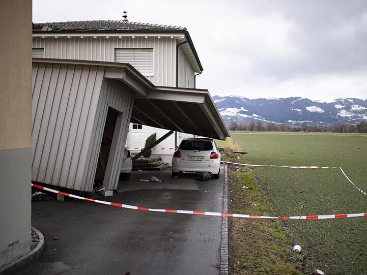 Das Dach eines beschädigten Hauses ragt nach Sturm "Uwe" auf ein davor geparktes Auto.
