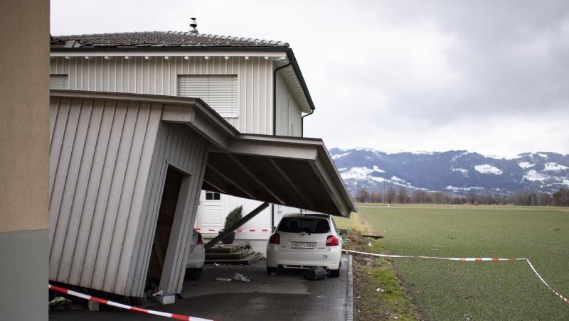 Das Dach eines beschädigten Hauses ragt nach Sturm "Uwe" auf ein davor geparktes Auto.