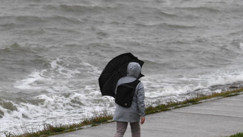 Ein Frau geht bei Regen und Wind spazieren. Tief "Mortimer" zieht von den Britischen Inseln über die Nordsee und weiter zur Ostsee. Ein Frau geht bei Regen und Wind spazieren. Tief "Mortimer" zieht von den Britischen Inseln über die Nordsee und weiter zur Ostsee.