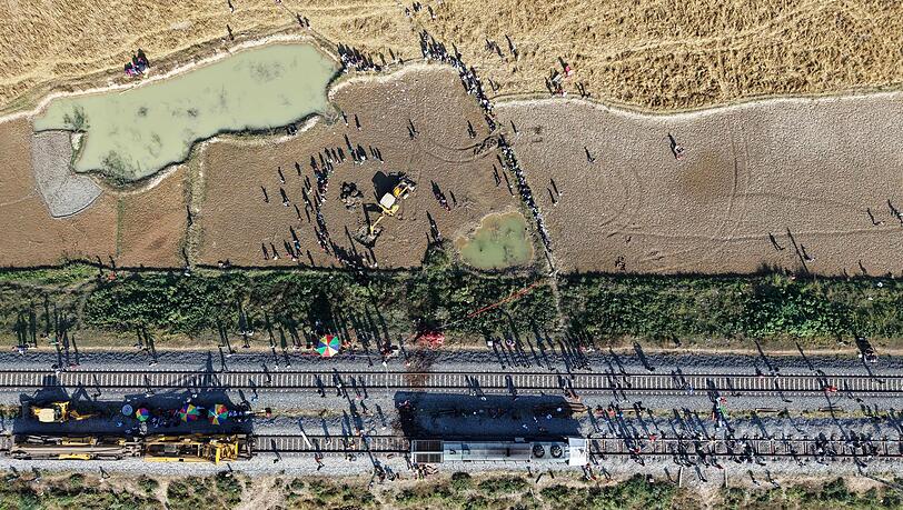 Ein Bagger hebt eine Grube aus, um den Kadaver eines Elefanten zu begraben, der bei der Kollision mit einem Zug ums Leben kam.