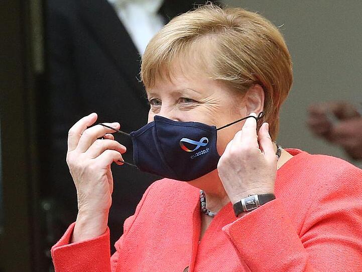 Bundeskanzlerin Angela Merkel (CDU) nimmt im Bundesrat ihre Mund- und Nasenschutzmaske ab, bevor sie eine Rede zu Zielen der EU-Ratspräsidentschaft hält.