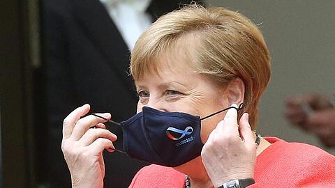 Bundeskanzlerin Angela Merkel (CDU) nimmt im Bundesrat ihre Mund- und Nasenschutzmaske ab, bevor sie eine Rede zu Zielen der EU-Ratspräsidentschaft hält.
