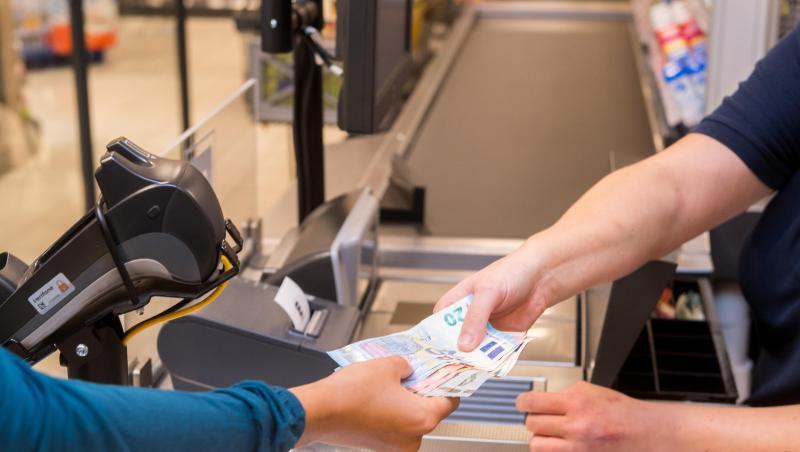 In einem Supermarkt hebt eine Kundin beim Bezahlen auch gleich Bargeld ab.