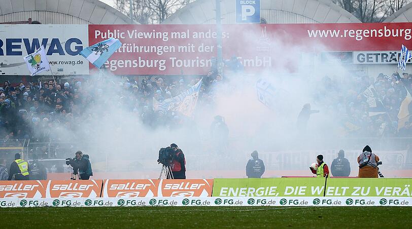 Unschöne Szenen in Regensburg. Aufgrund von Bengalos muss die Partie kurzzeitig unterbrochen werden. Aushilfs-Kapitän Daniel Bierofka muss den Fanblock beruhigen. Die Bilder zum durchklicken.