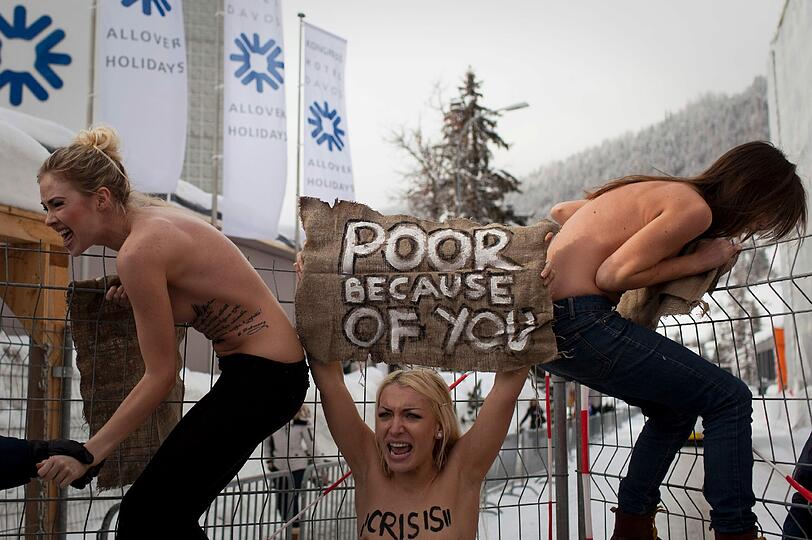 Nacktprotest in Davos: Ukrainerinnen demonstrieren barbusig am Zaun vor dem Weltwirtschaftsforum. Die Polizei greift ein - die Bilder.