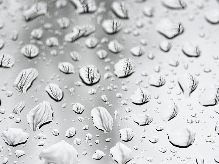 Regentropfen auf einer Glasscheibe sind zu sehen. Foto: Mohssen Assanimoghaddam/dpa/Archiv