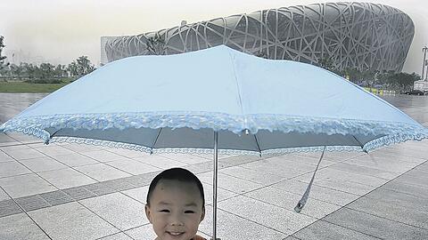 Alles machbar, auch das Wetter? Bei der Eröffnungsfeier am Freitag jedenfalls hätte dieser kleine Chinese trotz drohender Unwetter seinen Schirm nicht gebraucht. Und der leichte Regen, der gestern in Peking fiel, sei wirklich &bdquo;ganz natürlich&ldquo;, versichern Chinas Meteorologen.