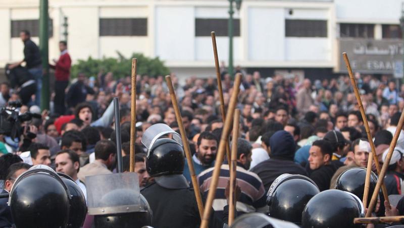 Die Polizisten gehen mit Schlagstöcken auf Demonstranten los. Die Polizisten gehen mit Schlagstöcken auf Demonstranten los.