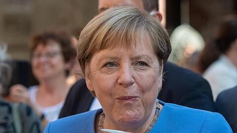 Bundeskanzlerin Angela Merkel (CDU) trinkt bei der Stralsunder Stadtwache ein Bier.