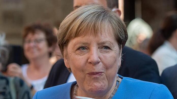 Bundeskanzlerin Angela Merkel (CDU) trinkt bei der Stralsunder Stadtwache ein Bier.