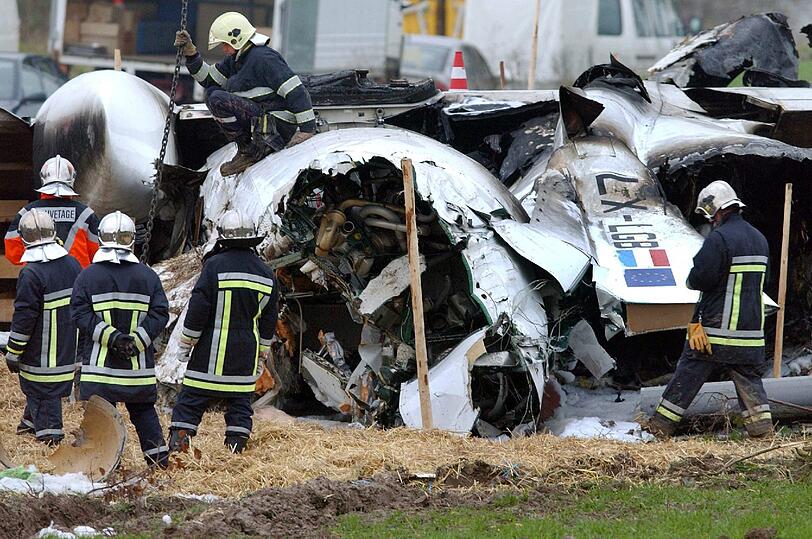 Rettungshelfer stehen am 06.11.2002 am Wrack einer Maschine vom Typ Fokker 50 der Luxair, die bei Niederanven abgestürzt ist. Der Flug der Luxair-Maschine von Berlin nach Luxemburg  endete mit einer tödlichen Katastrophe.