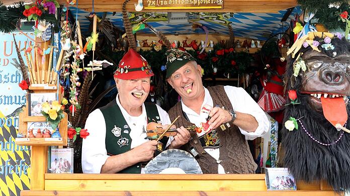 Horst und Tobi Berger stehen mit ihrem Vogelpfeiferlstand zwischen Bavaria und Käferzelt.