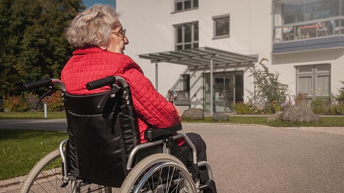 Eine Heimbewohnerin im Rollstuhl - viele Pflegebedürftige verbringen ihre letzten Tage in Kliniken. (Symbolbild)