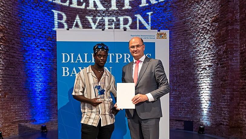 Heimatminister Albert Füracker übergibt Noah Hansen den Dialektpreis.