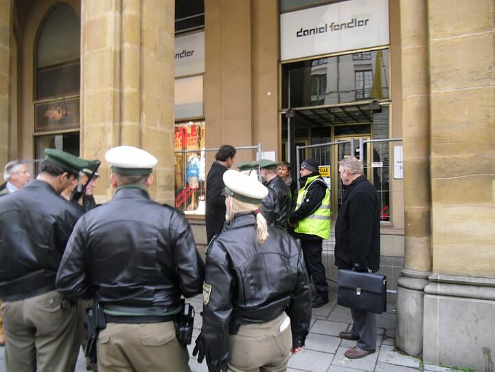 Auflauf auf der Maximilianstraße: Arkaden-Besitzer Urs Brunner (M.) inmitten von Polizisten. Foto: T. Gautier