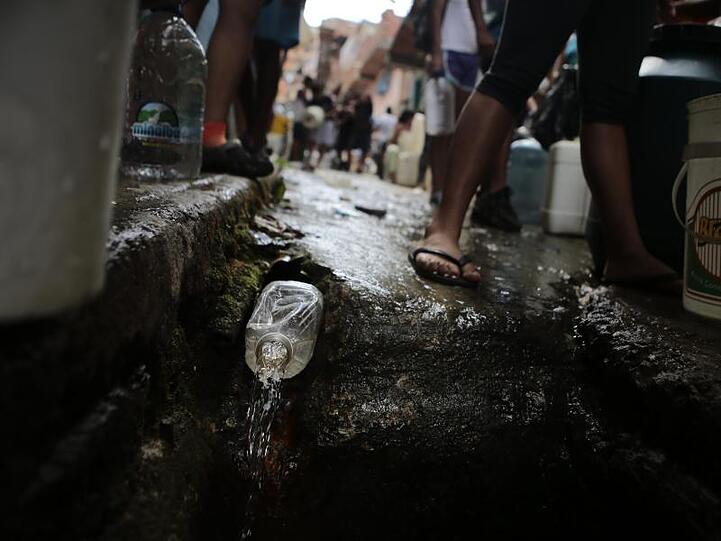 Eine Plastikflasche dient als Zapfhahn an einer Wasserleitung in einem ärmeren Viertel von Caracas, das aufgrund des massiven Stromausfalls keine Wasserversorgung hat.