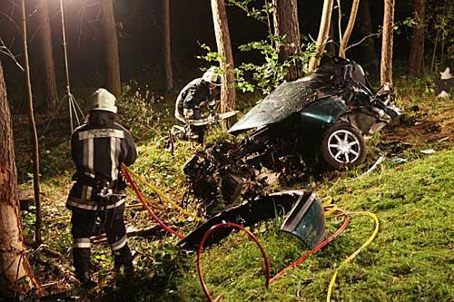 Ein Feuerwehrmann steht am Freitagabend(10.09.2010) neben dem Wrack eines verunglückten Autos bei Hemhofen (Mittelfranken.)
