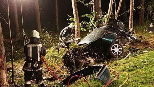 Ein Feuerwehrmann steht am Freitagabend(10.09.2010) neben dem Wrack eines verunglückten Autos bei Hemhofen (Mittelfranken.) Ein Feuerwehrmann steht am Freitagabend(10.09.2010) neben dem Wrack eines verunglückten Autos bei Hemhofen (Mittelfranken.)