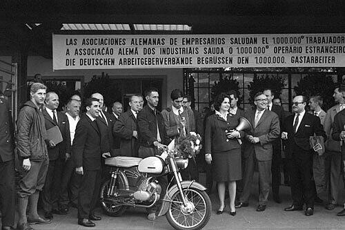 Armado Rodrigues aus Vale de Madeiros in Portugal, der millionste Gastarbeiter, bekam bei seiner Ankunft ein Moped überreicht.