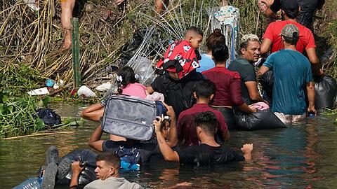Migranten durchqueren den Grenzfluss Rio Grande zwischen Mexiko und den USA.