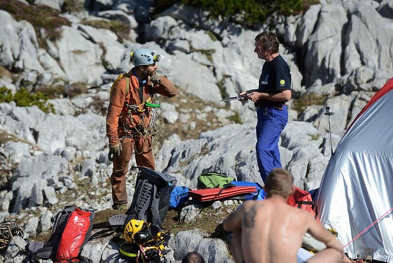 Ein in italienischer Höhlenretter (l) unterhält sich mit dem Einsatzleiter der Bergwacht am Untersberg.