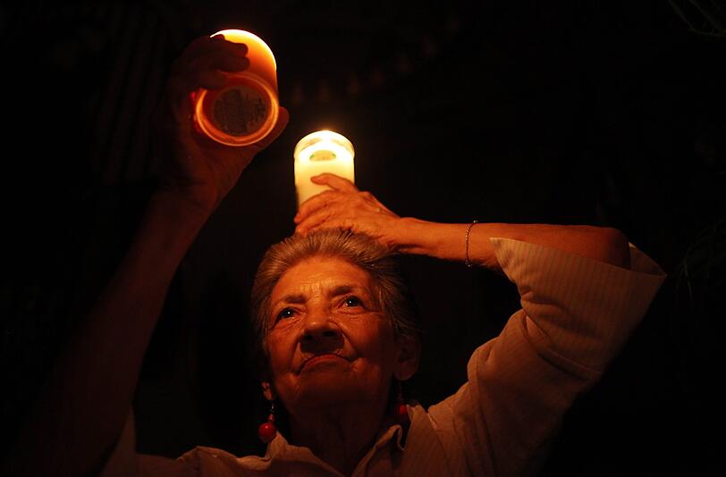 Eine Frau trägt eine Kerze während der Heiligen Ostermesse in Santo Domingo, Dominikanische Republik.