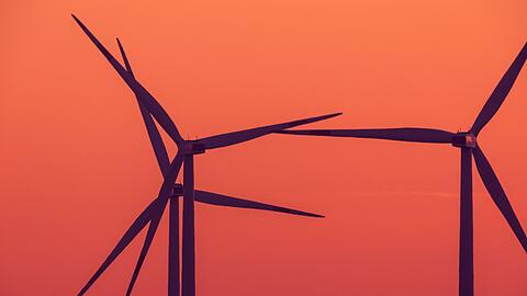 Die Rotoren von Windkraftanlagen drehen sich nach Sonnenuntergang.