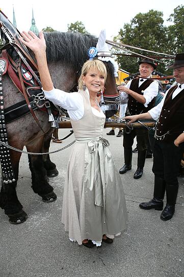 Trendy: Schauspielerin Uschi Glas trägt ein langes, klassisches Dirndl, aber sie beweist Fashion-Fingerspitzengefühl bei der Farbwahl: Taupe ist der Ton der Theresienwiese 2014.