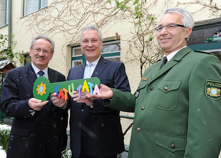 Muenchens Oberbuergermeister Christian Ude (SPD, v.l.), der bayerische Innenminister Joachim Herrmann (CSU) und Muenchens Polizeipraesident Wilhelm Schmidbauer posieren am Montag in Muenchen mit einem symbolischen Schluessel vor der ersten polizeilichen Kindertagesstaette, "Tatu Tata".