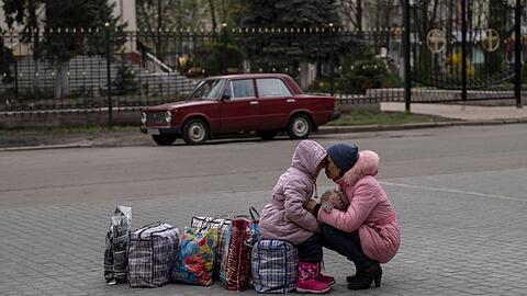 Eine Mutter wartet mit ihrer Tochter auf einen Bus, um aus der Stadt Slowjansk im Nordwesten der Ukraine zu fliehen.
