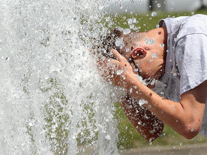 Bei noch sehr erträglichen Temperaturen um 29 Grad erfrischt sich ein junger Mann im Berliner Lustgarten an einem Brunnen. In den kommenden Tagen sollen die Temperaturen weiter steigen.