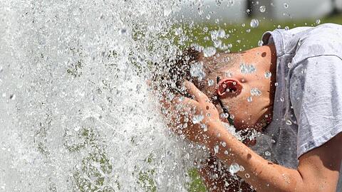Bei noch sehr erträglichen Temperaturen um 29 Grad erfrischt sich ein junger Mann im Berliner Lustgarten an einem Brunnen. In den kommenden Tagen sollen die Temperaturen weiter steigen.