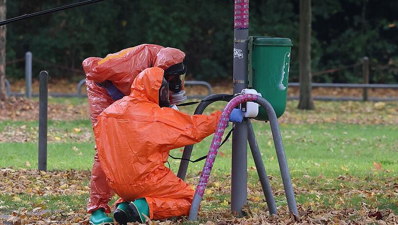 Feuerwehrleute überprüfen eine Mülltonne.