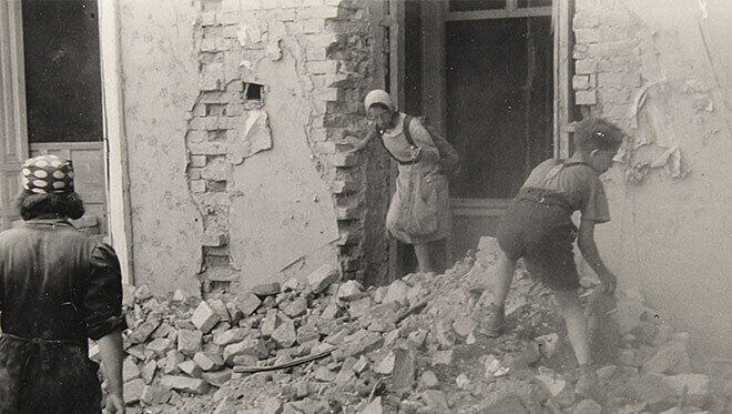 Ein harter Sommer: Eine Schülerin und ein Schüler räumen im August 1945 Steine vor einem ausgebombten Haus weg.