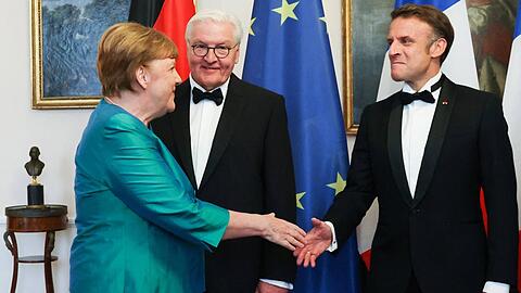 Nachdem sie Bundespräsident Frank-Walter Steinmeier begrüßt hatte, schüttelte Angela Merkel Emmanuel Macron herzlich die Hand.