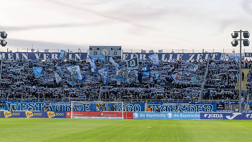 Schalparade der Löwenfans in der Westkurve des Grünwalder Stadions. Gut zu erkennen: Das große Banner „Mein Verein für alle Zeit“ links und rechts der Anzeigetafel. Schalparade der Löwenfans in der Westkurve des Grünwalder Stadions. Gut zu erkennen: Das große Banner „Mein Verein für alle Zeit“ links und rechts der Anzeigetafel.