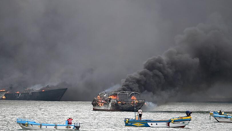 Im Hafen von Manta stehen mehrere Fischerboote in Flammen. Im Hafen von Manta stehen mehrere Fischerboote in Flammen.