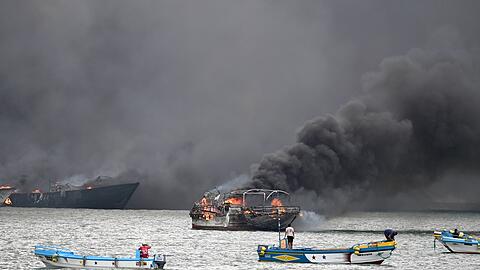 Im Hafen von Manta stehen mehrere Fischerboote in Flammen.