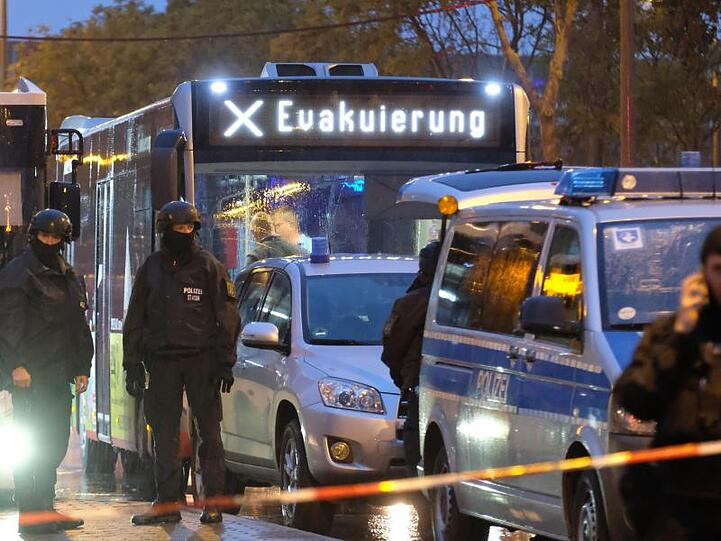 Ein Bus mit der Aufschrift "Evakuierung" wird von Polizei eskortiert . Bei Schüssen in Halle sind zwei Menschen getötet worden.
